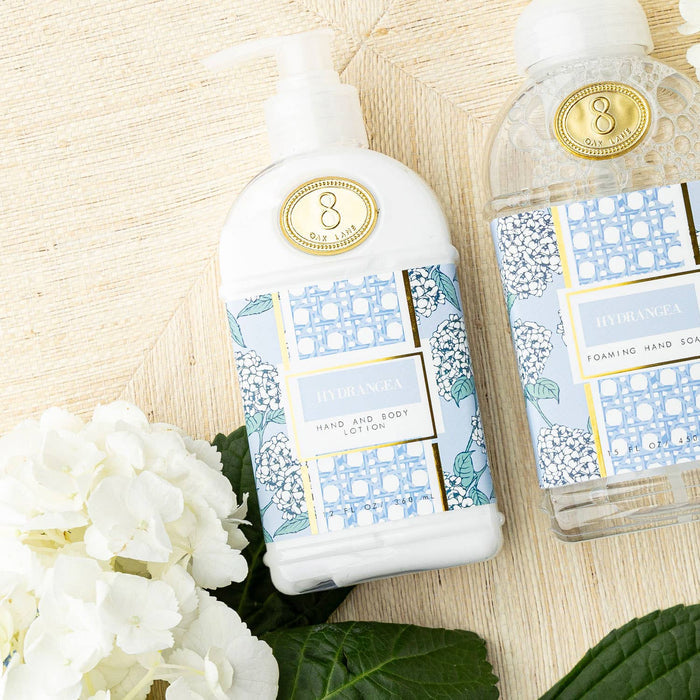 Two bottles of skincare products with decorative labels on a natural background with flowers.