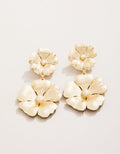 Gold floral earrings on a light beige background