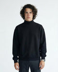 Man wearing a black turtleneck sweater against a white background
