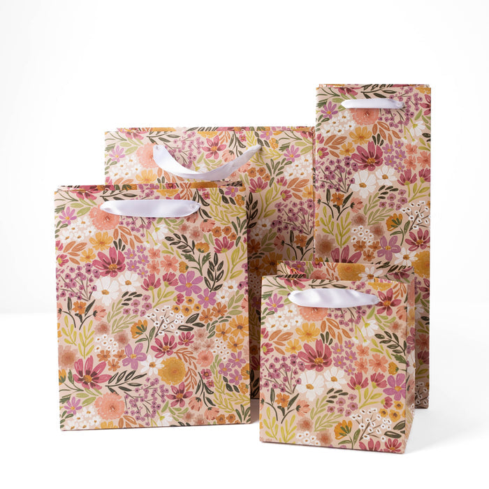 Set of three floral-patterned gift bags on a white background