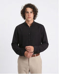 Man wearing a black shirt and beige pants on a white background